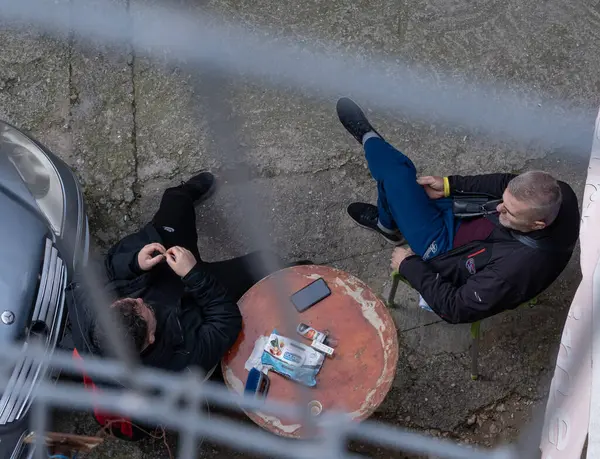 Tiran, Arnavutluk; 14 Şubat 2025: Sokaklarda oturan erkekler. Üst görünüm