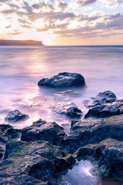 Denizin üzerinde gün batımının uzun pozlama fotoğrafları.