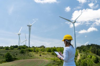 Rüzgar tarlasında rüzgar türbinli kadın mühendis