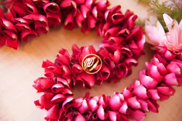 Alyanslar güzel kırmızı bir çiçek deseninde birlikte sergilenir. Altın yüzükler.