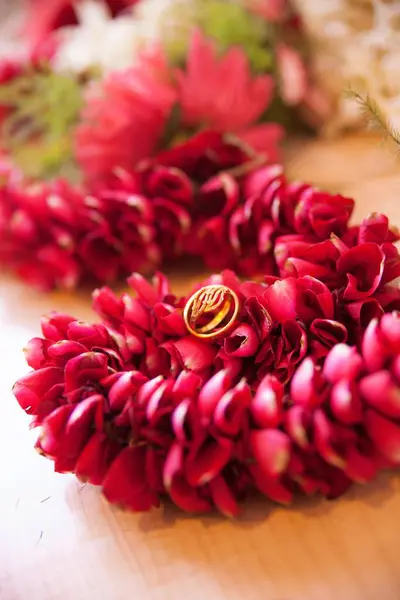 Alyanslar güzel kırmızı bir çiçek deseninde birlikte sergilenir. Altın yüzükler.