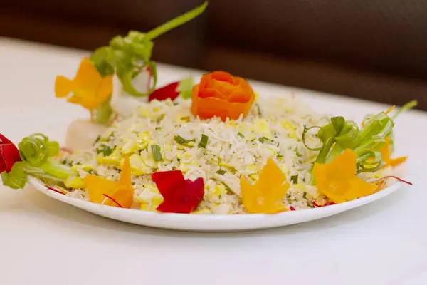 Wok-Atmalı Mükemmellik. Renkli kapsiyum ve aromatik taze soğanla ustalıkla süslenmiş Çin Tavuğu Kızarmış Pirincinin göz kamaştırıcı bir sunumu otantik Asya mutfağının özünü çağrıştırıyor..