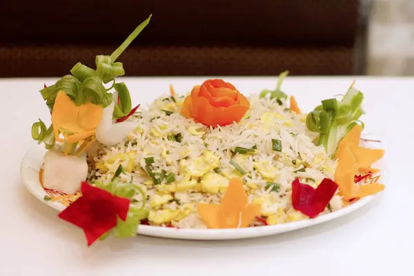 Wok-Atmalı Mükemmellik. Renkli kapsiyum ve aromatik taze soğanla ustalıkla süslenmiş Çin Tavuğu Kızarmış Pirincinin göz kamaştırıcı bir sunumu otantik Asya mutfağının özünü çağrıştırıyor..