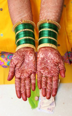 Güzel bir Henna tasarımı Hintli kadınların özel durumlar için en sevdiği süs ve makyajdır. Bir gelinin elleri ustalar tarafından sanatsal dövmeyle kaplıdır.. 