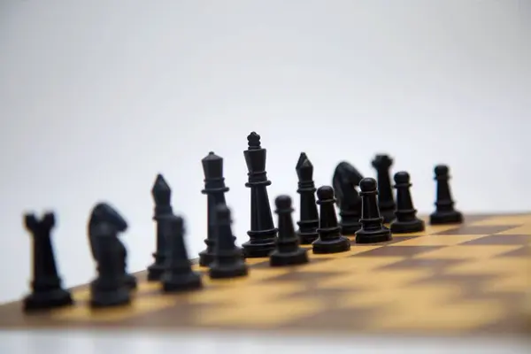 Kara Kral ordusunu yönetiyor. Stratejik olarak düzenlenmiş siyah taşlı bir satranç tahtası manzarası. Düzenleme, stratejik bir hamleden bir dakika öncesini gösteriyor..