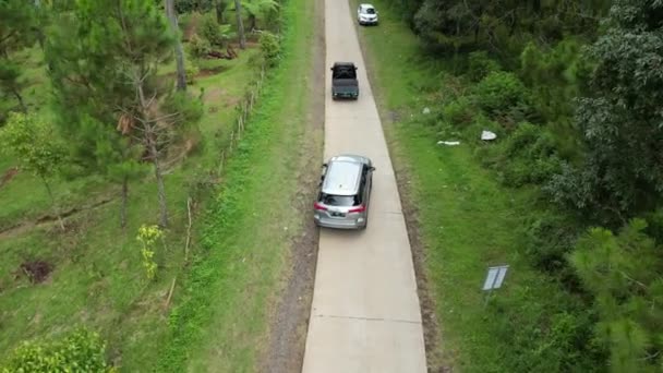 インドネシア ランバン 2024年3月18日 無人機の視界を追跡する車の旅 空中映像で撮影された風光明媚な森林道路 — ストック動画