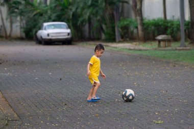 Sarı Giysili Küçük Çocuk Evinin Yakınındaki Bir Parkta Futbol Oynuyor