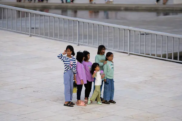 Bir grup çocuk ve kız Lapangan Banteng 'de fotoğraf çekimi için hazırlanıyor.