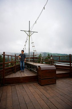 Asian Man Standing on a Wooden Deck of a Ship, Phinisi Lembang clipart