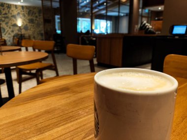 Sıcak bir fincan Cappucino Kahve, Cozy Cafe 'deki Tahta Masa' da bir kahve fincanında.