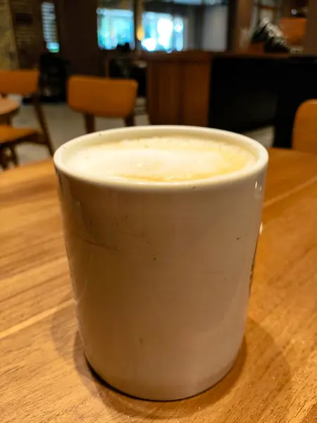 Sıcak bir fincan Cappucino Kahve, Cozy Cafe 'deki Tahta Masa' da bir kahve fincanında.
