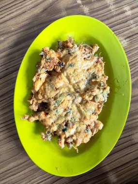 Parlak yeşil bir tabakta servis edilen basit ama lezzetli Endonezya usulü kızarmış yumurta, hızlı bir atıştırmalık için mükemmel, Telur Dadar..