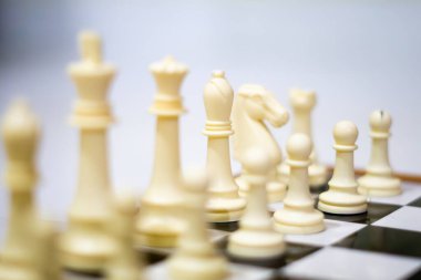 Satranç tahtası ilk kurulum senaryosunu sergiliyor, eleştirel düşünme ve strateji geliştirme üzerine odaklanmış öğretici içeriği, yarışmaları veya beyin oyunlarını temsil ediyor.