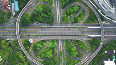 Üzerinde büyük bir köprü ve arka planda bir şehir olan bir otoyol. Çevre yolu ağaçlar ve otlarla çevrilidir.