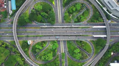 Üzerinde büyük bir köprü ve arka planda bir şehir olan bir otoyol. Çevre yolu ağaçlar ve otlarla çevrilidir.
