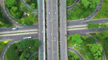 Üzerinde büyük bir köprü ve arka planda bir şehir olan bir otoyol. Çevre yolu ağaçlar ve otlarla çevrilidir.