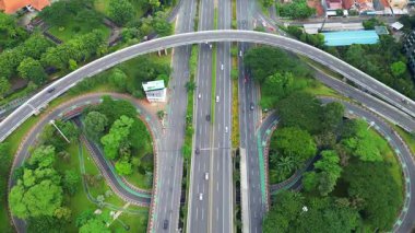 Üzerinde büyük bir köprü ve arka planda bir şehir olan bir otoyol. Çevre yolu ağaçlar ve otlarla çevrilidir.