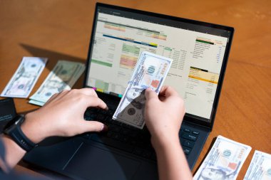 Temiz bir çalışma alanı üzerinde bütçe uygulaması tablosu kullanarak kişisel finansman yöneten bir kişinin omuz üstü çekimi.