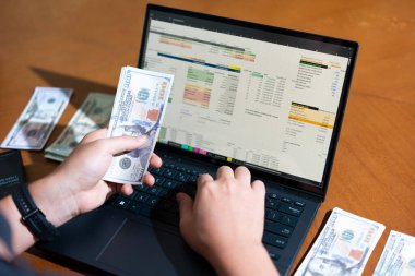 Temiz bir çalışma alanı üzerinde bütçe uygulaması tablosu kullanarak kişisel finansman yöneten bir kişinin omuz üstü çekimi.