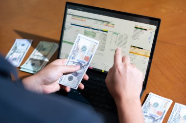 Temiz bir çalışma alanı üzerinde bütçe uygulaması tablosu kullanarak kişisel finansman yöneten bir kişinin omuz üstü çekimi.