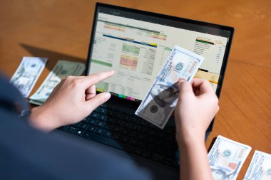 Temiz bir çalışma alanı üzerinde bütçe uygulaması tablosu kullanarak kişisel finansman yöneten bir kişinin omuz üstü çekimi.