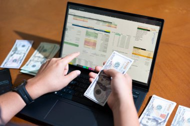 Temiz bir çalışma alanı üzerinde bütçe uygulaması tablosu kullanarak kişisel finansman yöneten bir kişinin omuz üstü çekimi.