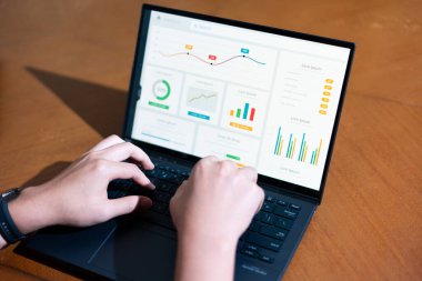 Ekranda grafik olan bir kişi dizüstü bilgisayarda yazıyor. Grafik bir düşüş eğilimi gösteriyor, bu da satışlarda bir düşüş ya da olumsuz bir sonuç anlamına gelebilir.