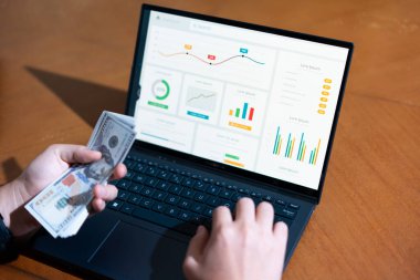 Bir kişi banka hesabına para yatırmak için dizüstü bilgisayar kullanıyor. Mali sorumluluk kavramı ve kişinin mali durumunu idare etmesinin önemi