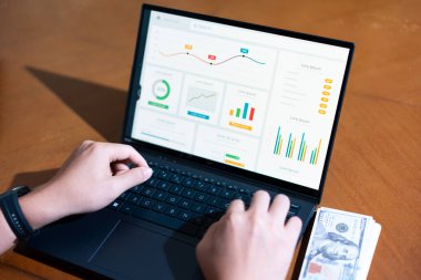 Ekranda grafik olan bir kişi dizüstü bilgisayarda yazıyor. Grafik bir düşüş eğilimi gösteriyor, bu da satışlarda bir düşüş ya da olumsuz bir sonuç anlamına gelebilir.