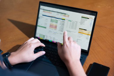 Temiz bir çalışma alanı üzerinde bütçe uygulaması tablosu kullanarak kişisel finansman yöneten bir kişinin omuz üstü çekimi.