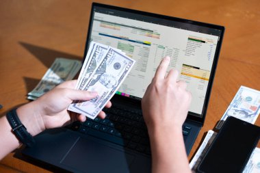 Temiz bir çalışma alanı üzerinde bütçe uygulaması tablosu kullanarak kişisel finansman yöneten bir kişinin omuz üstü çekimi.