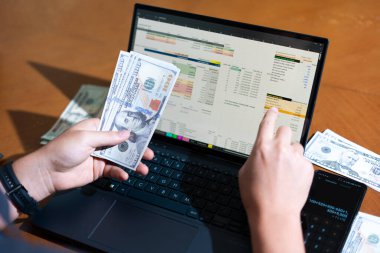 Temiz bir çalışma alanı üzerinde bütçe uygulaması tablosu kullanarak kişisel finansman yöneten bir kişinin omuz üstü çekimi.