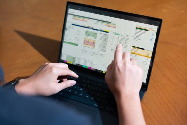 Temiz bir çalışma alanı üzerinde bütçe uygulaması tablosu kullanarak kişisel finansman yöneten bir kişinin omuz üstü çekimi.