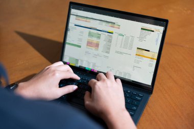 Temiz bir çalışma alanı üzerinde bütçe uygulaması tablosu kullanarak kişisel finansman yöneten bir kişinin omuz üstü çekimi.