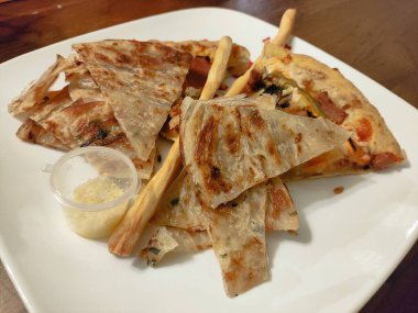 Bir tabak yemek, bir dilim pizza ve bir parça ekmek. Pizza küçük parçalara bölündü ve ekmek de kenarda kaldı.