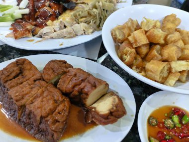 Et, sebze ve erişte gibi çeşitli yemeklerle dolu bir tabak. Sahne davetkar ve lezzetli.