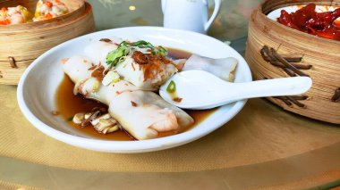 Çin gamzesi, üzerinde kaşık olan bir tabak yemek. Tabak yemekle dolu ve kaşık tabağın sağ tarafında.