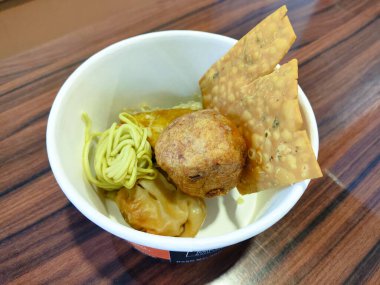 Bir kase yiyecek, çeşitli atıştırmalıklar, baso goreng, masada pangsit.