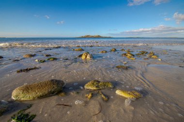 Dalgalar Breton kıyısındaki engebeli uçurumlara çarparak beyaz sprey ve ham güçle dramatik bir gösteri yaratıyor. Deniz ve taşın etkileşimi bu yabani bölgenin vahşi güzelliğini somutlaştırıyor..