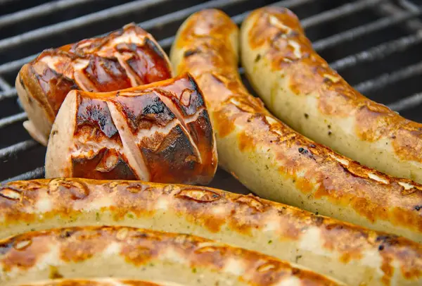 Sulu ızgara sosisler ahşap bir ızgarada cızırdıyor dumanlı aromaları havayı dolduruyor. Açık ateşte mükemmel pişmiş, ağız sulandırıcı bir yemek ve yaz ızgarası sunuyorlar.