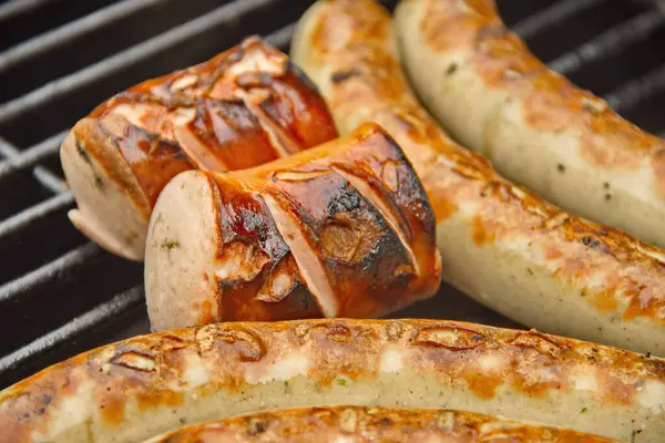 Sulu ızgara sosisler ahşap bir ızgarada cızırdıyor dumanlı aromaları havayı dolduruyor. Açık ateşte mükemmel pişmiş, ağız sulandırıcı bir yemek ve yaz ızgarası sunuyorlar.