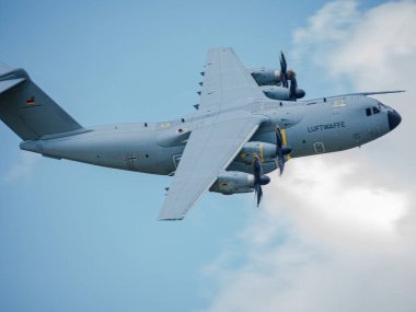 NATO tatbikatı sırasında bir Alman Hava Kuvvetleri Airbus A400M: Kamuflaj üniformalı modern askeri nakliye uçakları, teçhizat ve askerlerle dolu bir saha pistinden kalkıyor, görev koordinasyonu