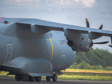 NATO tatbikatı sırasında bir Alman Hava Kuvvetleri Airbus A400M: Kamuflaj üniformalı modern askeri nakliye uçakları, teçhizat ve askerlerle dolu bir saha pistinden kalkıyor, görev koordinasyonu