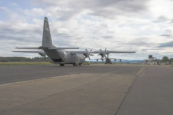 NATO tatbikatı sırasında ABD Hava Kuvvetleri 'ne bağlı bir C-130 Herkül harekât halindeki ikonik askeri nakliye uçağı, birlikleri, ekipmanları ve malzemeleri ortak operasyonlar için bir saha pistine teslim ediyor..