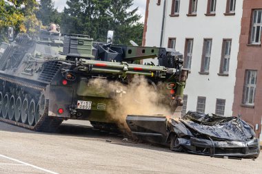 Alman Bundeswehr Wiesel ve Bffel zırhlı araçları eğitim sırasında bir arabayı ezerek askeri tatbikata katıldılar. Sahne, mekanize kuvvetlerin gücünü, taktiklerini ve ham gücünü gösteriyor..