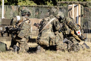 Alman Bundeswehr paraşütçüleri tüfek ve taktik teçhizatla NATO tatbikatına katıldılar. Askerler, savaş hazırlığı, takım çalışması ve acil müdahale eğitimleri sırasında yaralı yoldaşlara yardım ediyor..
