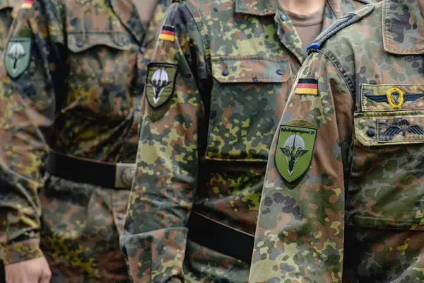 Alman Bundeswehr paraşütçüleri bir NATO etkinliğinde tüfek ve tam teçhizat taşıyarak sıraya girdiler. Üniformaları ve silahları disiplini, hazır olmayı ve uluslararası askeri işbirliğinin gücünü yansıtıyor..