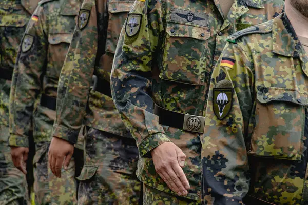 Alman Bundeswehr paraşütçüleri bir NATO etkinliğinde tüfek ve tam teçhizat taşıyarak sıraya girdiler. Üniformaları ve silahları disiplini, hazır olmayı ve uluslararası askeri işbirliğinin gücünü yansıtıyor..