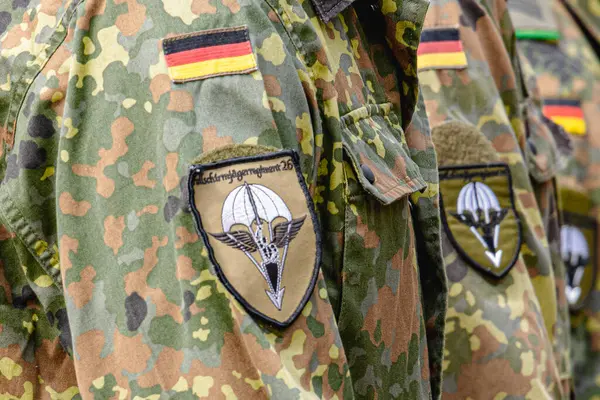 Alman Bundeswehr paraşütçüleri bir NATO etkinliğinde tüfek ve tam teçhizat taşıyarak sıraya girdiler. Üniformaları ve silahları disiplini, hazır olmayı ve uluslararası askeri işbirliğinin gücünü yansıtıyor..