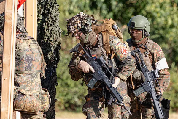 Alman Bundeswehr paraşütçüleri tüfek ve taktik teçhizatla NATO tatbikatına katıldılar. Askerler, savaş hazırlığı, takım çalışması ve acil müdahale eğitimleri sırasında yaralı yoldaşlara yardım ediyor..